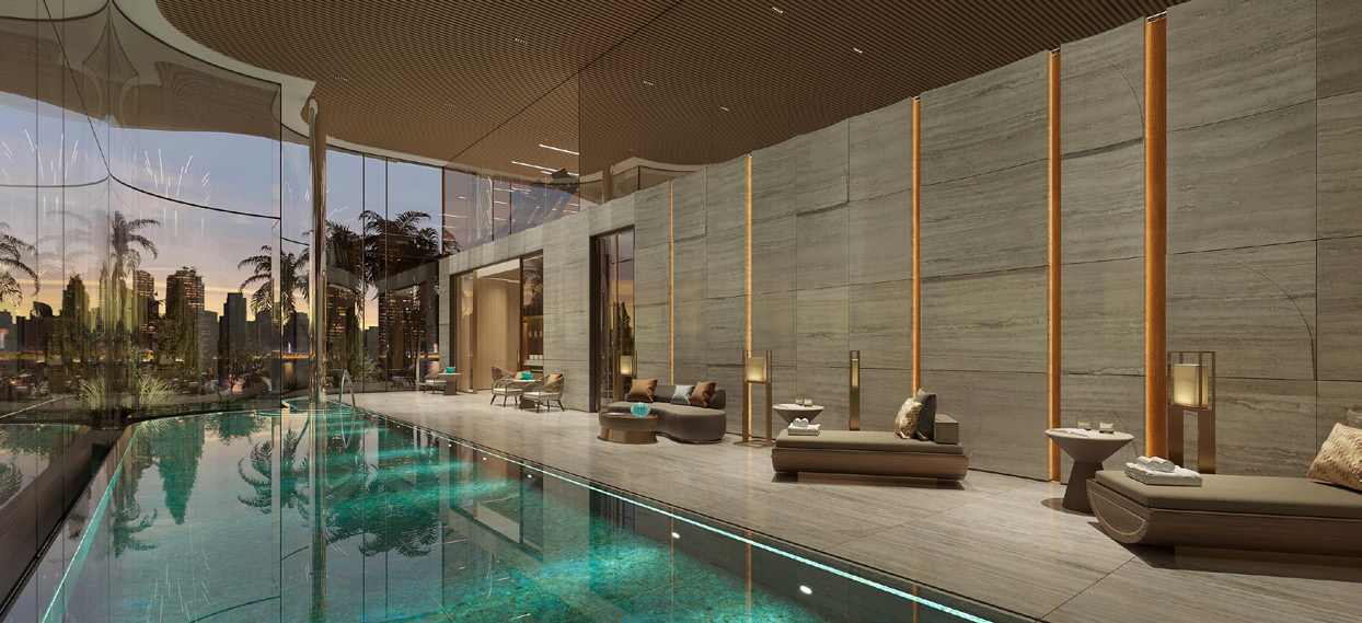 Indoor pool with stone walls, loungers and city views through glass