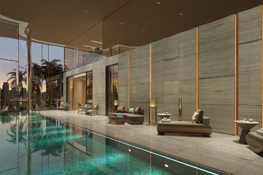 Indoor pool with stone walls, loungers and city views through glass